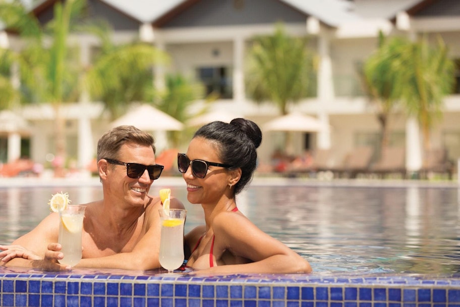 Koppel ontspant met een cocktail in het zwembad